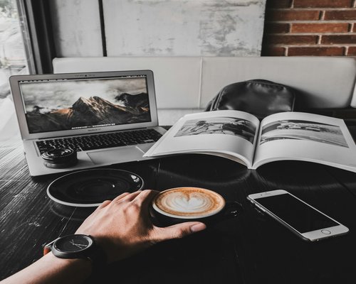A cup of coffee and a notebook on a desk in Bandung